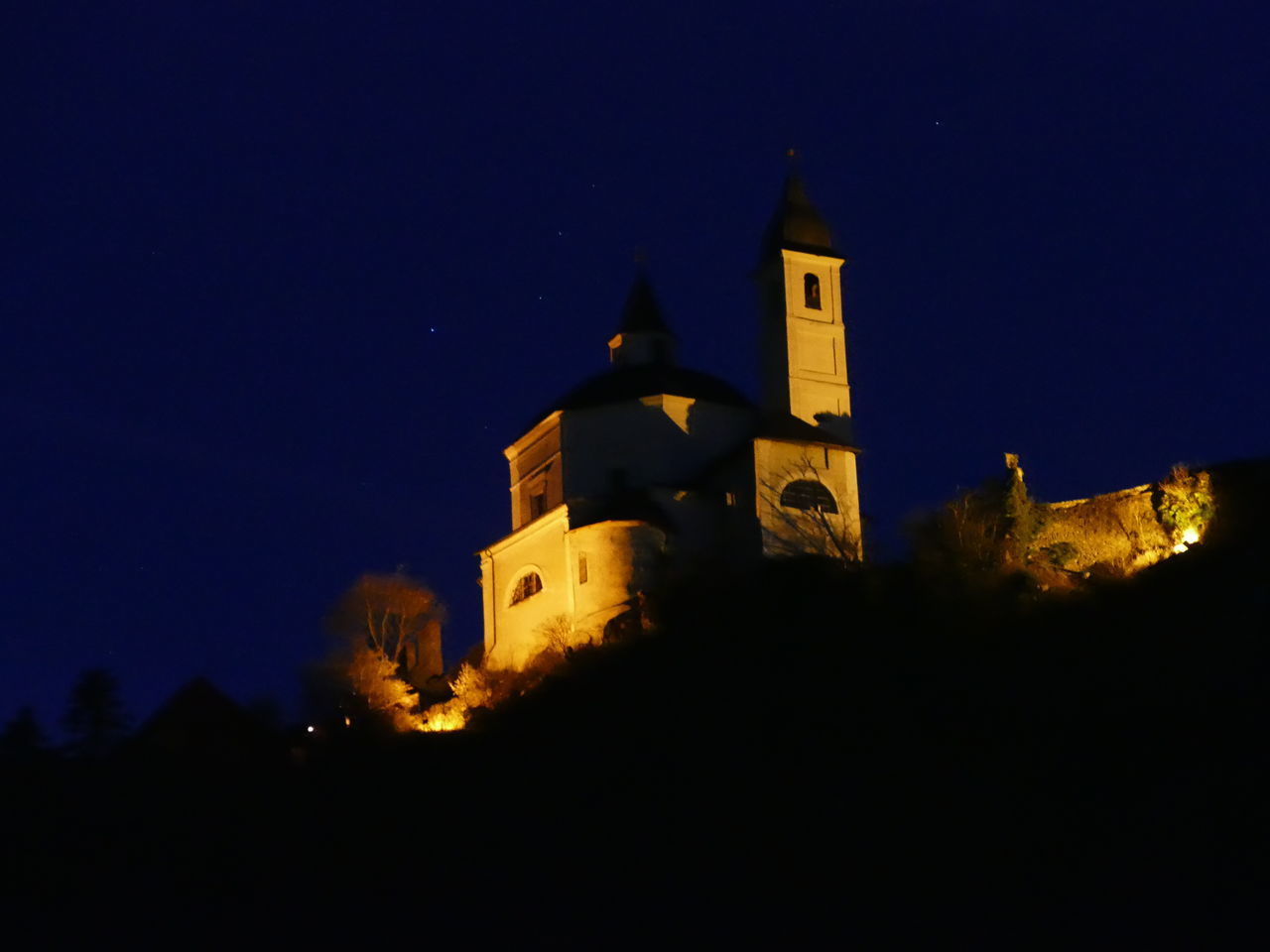 LOW ANGLE VIEW OF ILLUMINATED BUILDING AT NIGHT