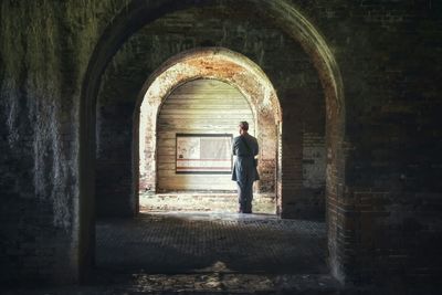 Rear view of man standing at archway