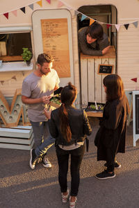 High angle view of customers and food truck owner on street