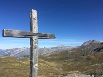 Cross on mountain against blue sky