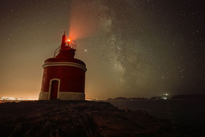 Lighthouse against sky at night