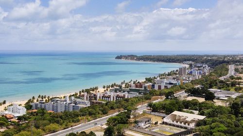 High angle view of sea and cityscape against sky