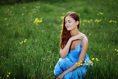 Portrait of young woman sitting on field