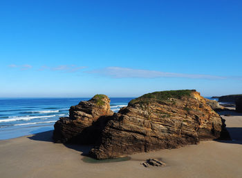 Rocks on beach against sky