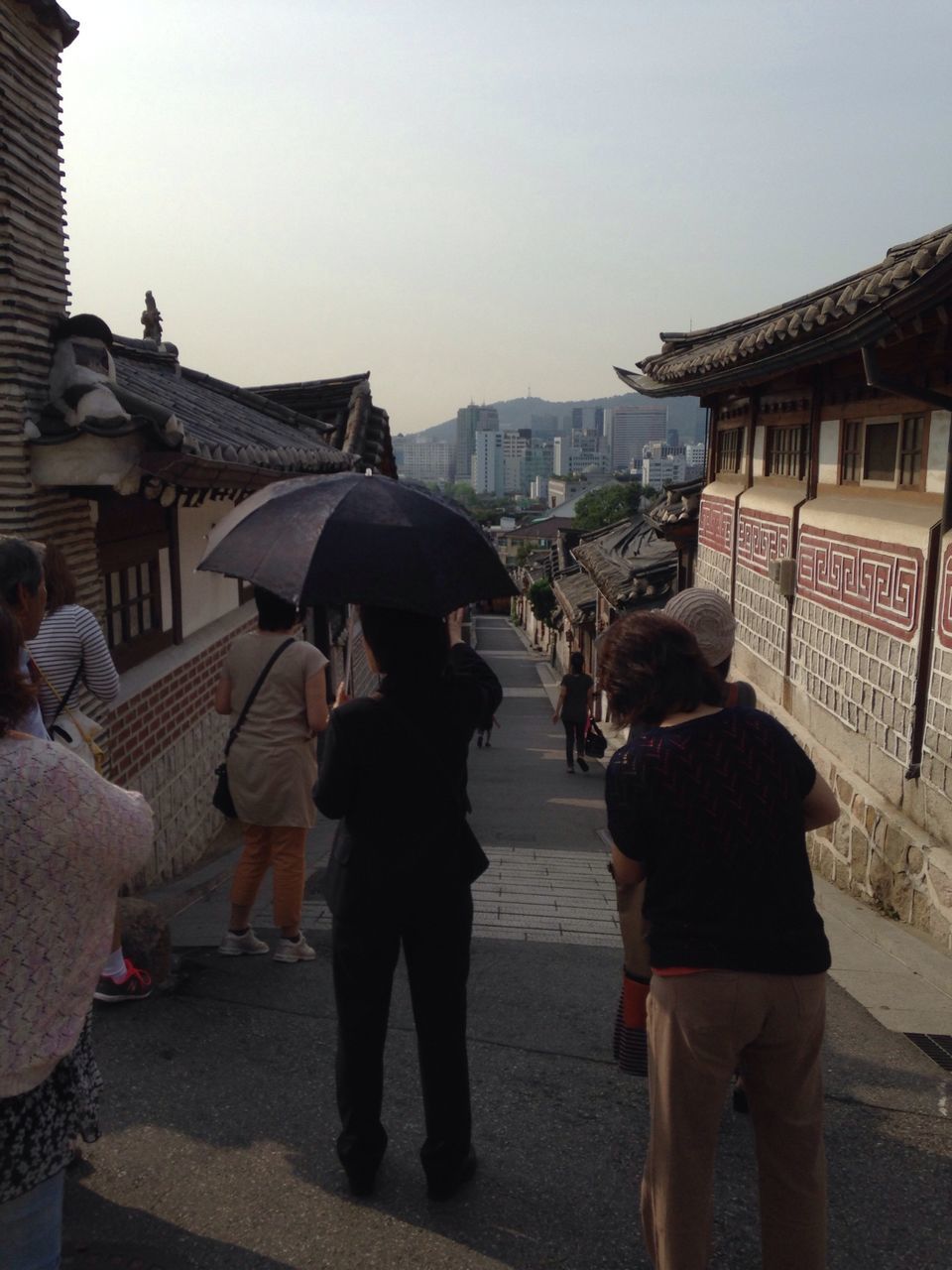 building exterior, men, architecture, built structure, lifestyles, person, clear sky, leisure activity, rear view, walking, city, casual clothing, street, togetherness, large group of people, full length, standing, city life