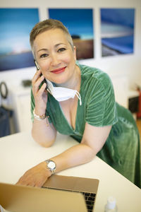 Smiling businesswoman on phone looking at camera