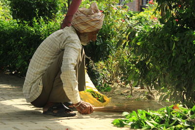 Side view of man climbing on plants