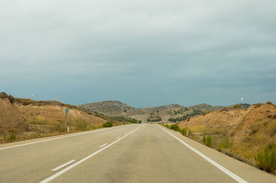 Empty road along countryside landscape