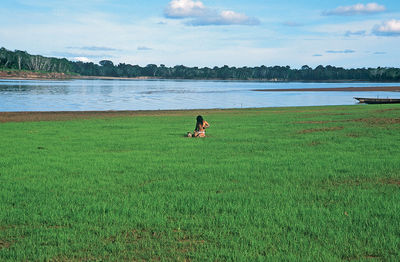 Person by lake on field 