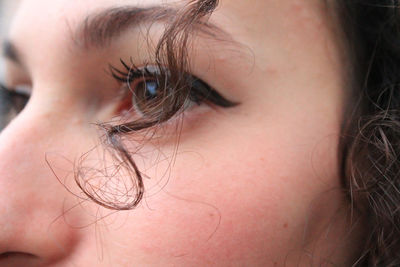 Close-up of woman with curly hair and eyeliner