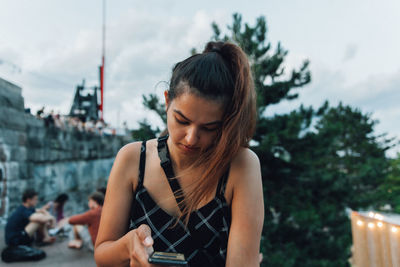 Young woman looking away against sky