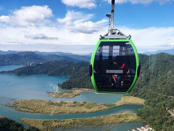 Overhead cable car over mountains against sky