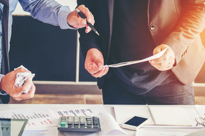 Midsection of businessmen working at desk in office