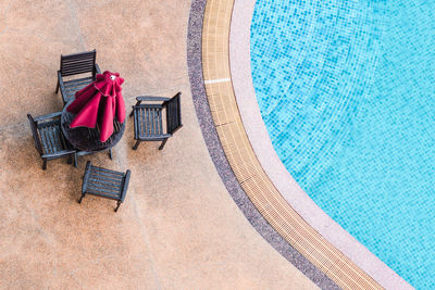 High angle view of chair by swimming pool