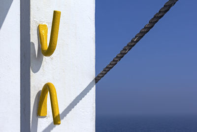 Close-up of yellow poles against blue sky