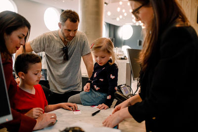 Receptionist giving keys to family at reception in hotel