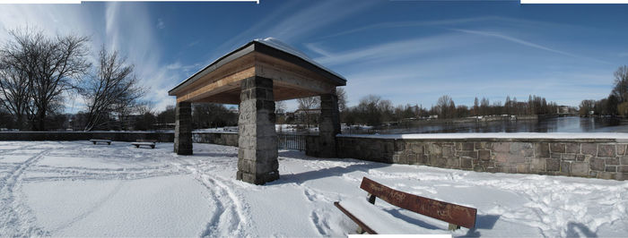 Gazebo by trees against sky during winter