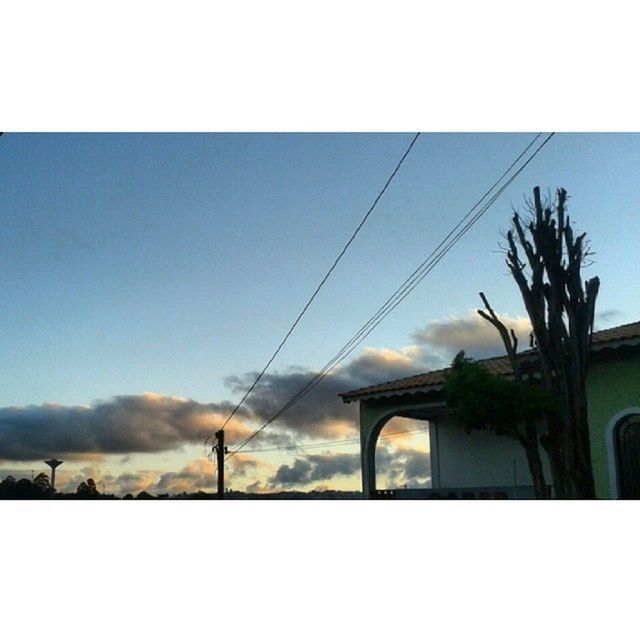 transfer print, power line, built structure, architecture, sky, auto post production filter, building exterior, tree, electricity pylon, cable, silhouette, connection, transportation, house, low angle view, window, no people, outdoors, power cable, sunset