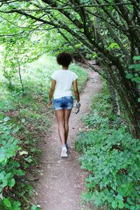 Rear view of woman walking in forest