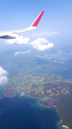 Airplane flying over landscape against sky