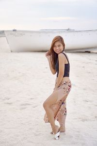 Full length portrait of young woman on beach