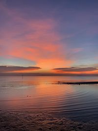 Scenic view of sea against romantic sky at sunset