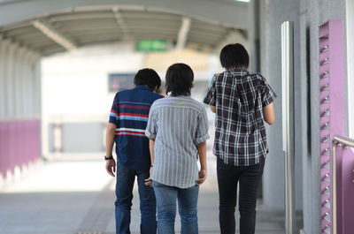 Rear view of friends walking in overpass
