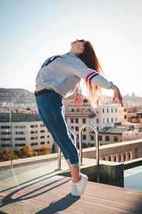 Full length of woman standing against buildings in city