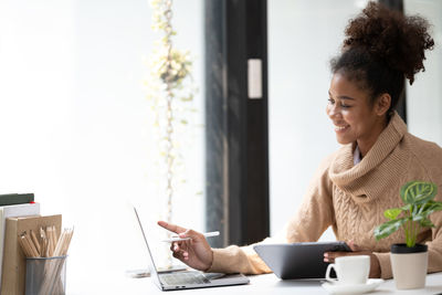 Young woman using laptop at table