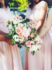 Midsection of bridesmaid holding bouquet