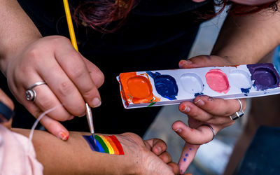 Lgbtq members painting on face and body during lgbtq rally .