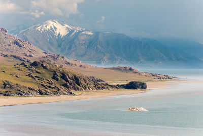 Scenic view of sea and mountains against sky