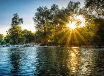 Scenic view of river against sky at sunset