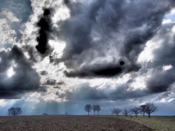 Scenic view of field against cloudy sky