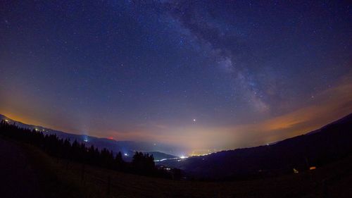 Silhouette landscape against star field at night