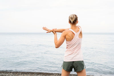 Rear view of young woman looking at sea