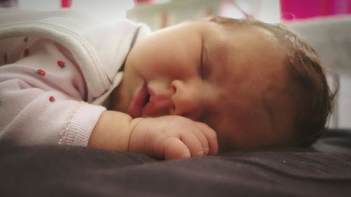 Close-up of baby sleeping on bed