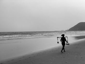 People on beach against clear sky