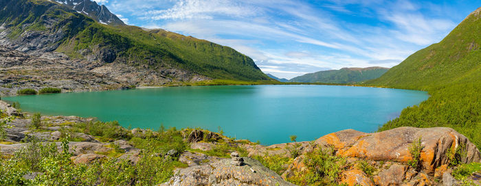 Scenic view of lake by mountains against sky