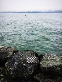 Close-up of rocks in sea against sky