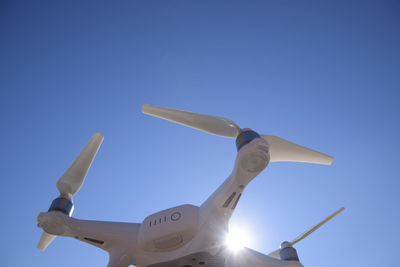 Low angle view of airplane against clear blue sky