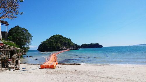 Scenic view of beach against clear blue sky