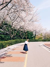 Woman standing on road against sky