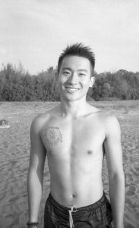 Portrait of shirtless man standing at beach