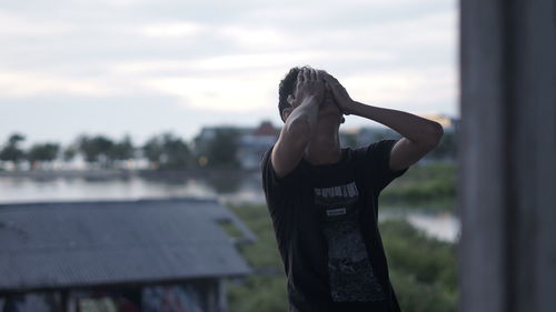 Woman standing with umbrella against sky