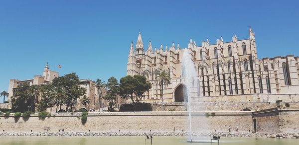 Low angle view of palma cathedral against clear blue sky