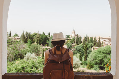 Man wearing hat against trees against clear sky