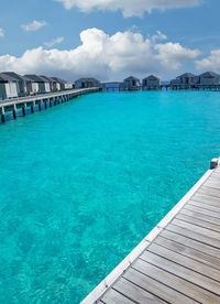 Scenic view of swimming pool by sea against sky