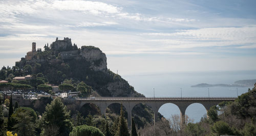 Arch bridge over river against cloudy sky