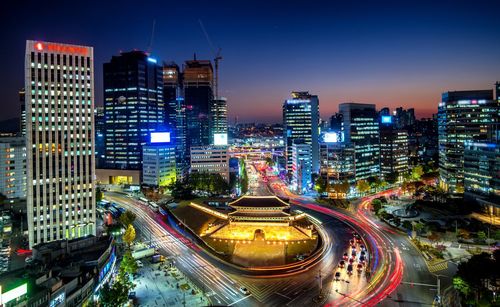 High angle view of illuminated city street and buildings at night